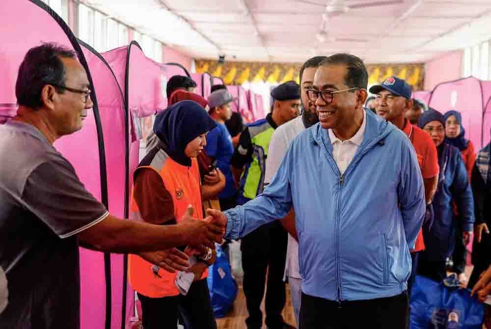 Menteri Pertahanan yang juga Ahli Parlimen Kota Tinggi, Datuk Seri Mohamed Khaled Nordin melawat dan menyampaikan bantuan barangan keperluan kepada mangsa banjir yang ditempatkan di SK Gembut Tanjung Sedili, Johor pada Sabtu. Foto Bernama