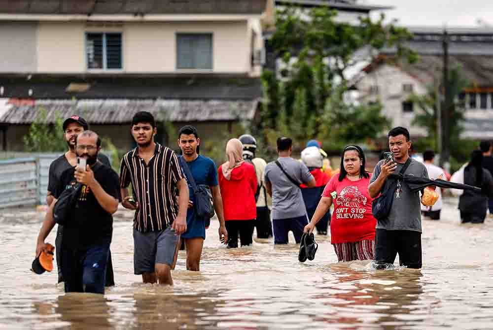 Penduduk meredah banjir dari kediaman ke PPS di Kota Tinggi pada 9 Januari lalu. Foto Bernama