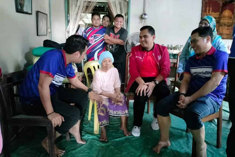 Muhamad Akmal (dua dari kanan) bertanya khabar mangsa banjir ketika Misi Bantuan Banjir Pemuda UMNO di Kluang, pada Sabtu.