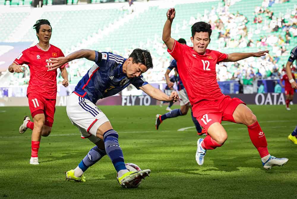 Pemain Jepun, Shogo Taniguchi mengasak pertahanan Vietnam pada perlawanan di antara Jepun menentang Vietnam peringkat Kumpulan D sempena Piala Asia 2023 di Stadium Al Thumama. Foto Bernama