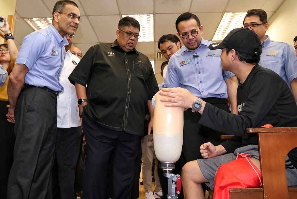 Dr Mohammed Azman (kiri), Ab Rauf (dua, kiri) dan Steven (tiga, kiri)
melihat seorang pesakit dari Selangor yang mengguna kaki palsu sebelum menjalani rawatan.