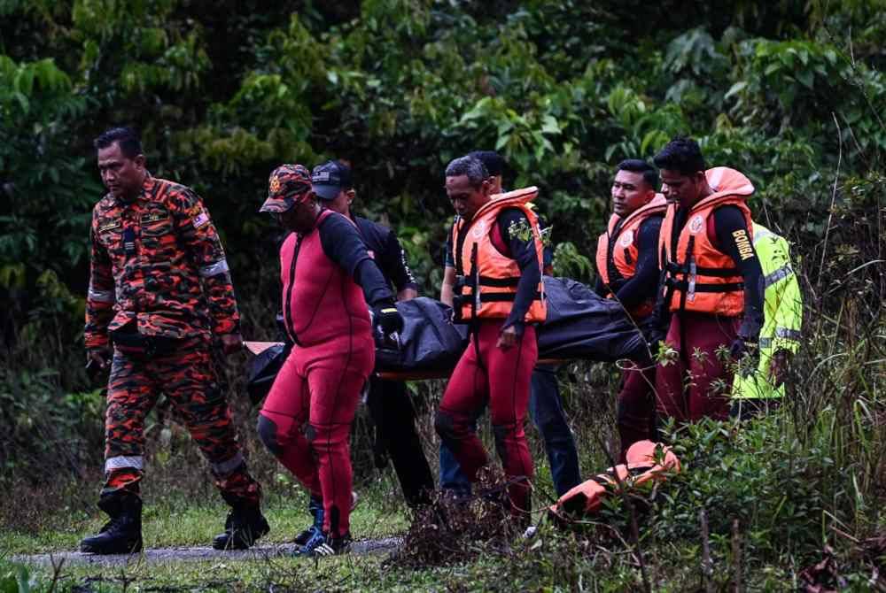 Anggota bomba mengangkat seorang mayat lelaki yang ditemui terapung di tali air Kampung Tetambah, Manir hari ini. Foto Bernama