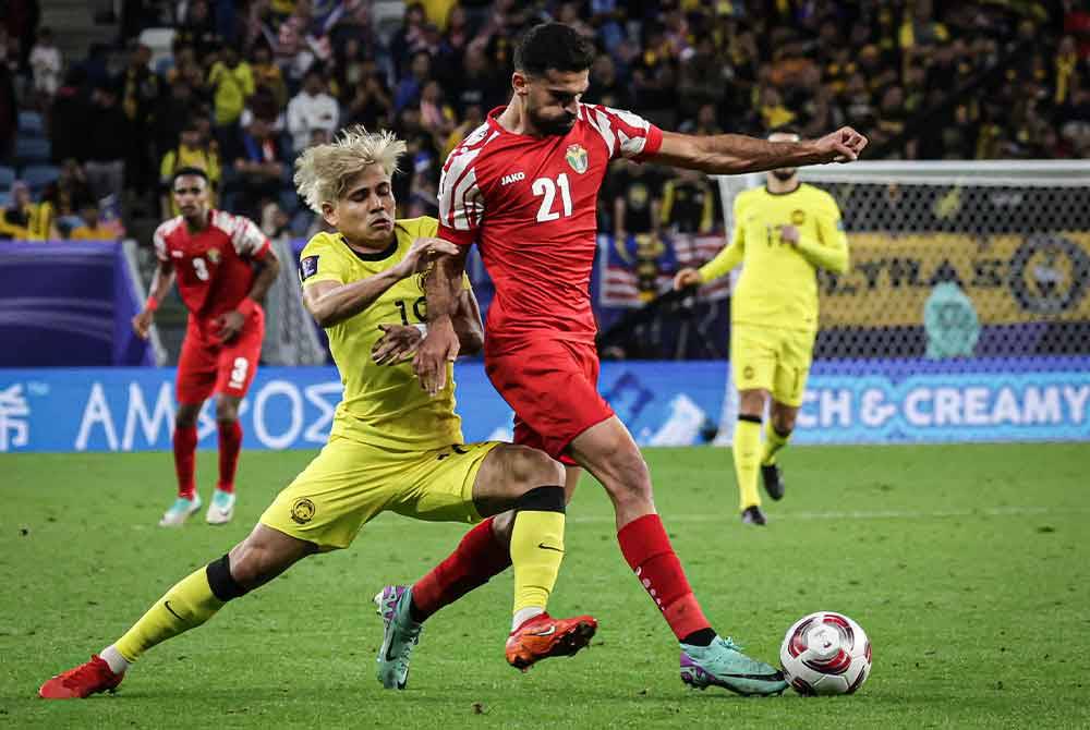 Pemain Malaysia, Akhyar Rashid mengasak pemain Jordan, Nizar Alrashidan pada perlawanan di antara Malaysia menentang Jordan bagi peringkat Kumpulan E sempena Piala Asia 2023 di Stadium Al Janoub. Foto Bernama