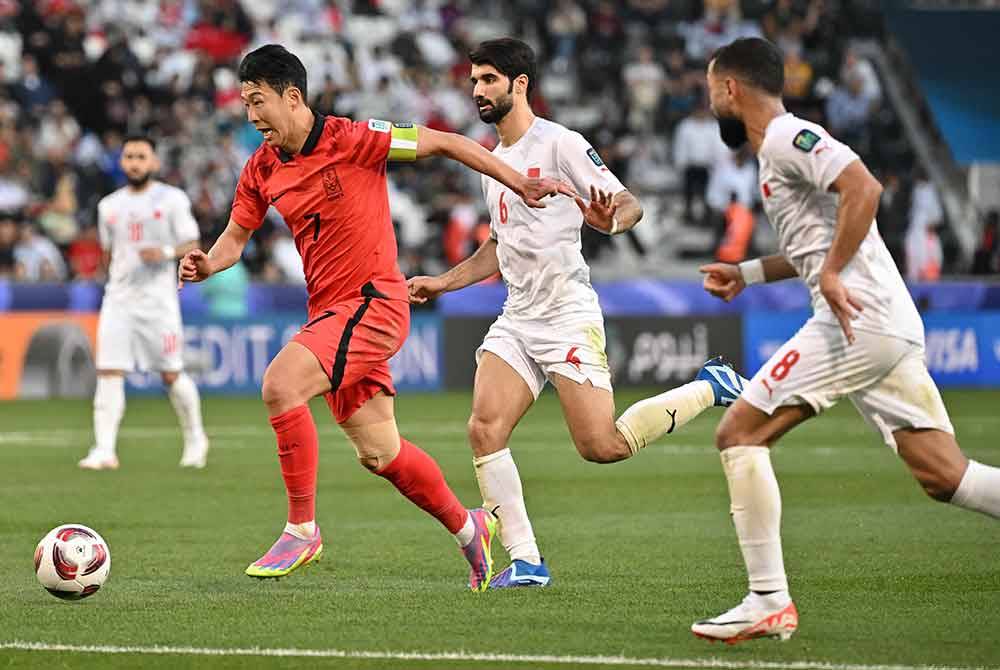 Heung-min (depan) mengatasi dua pemain Bahrain ketika aksi Kumpulan E Piala Asia. Foto AFP