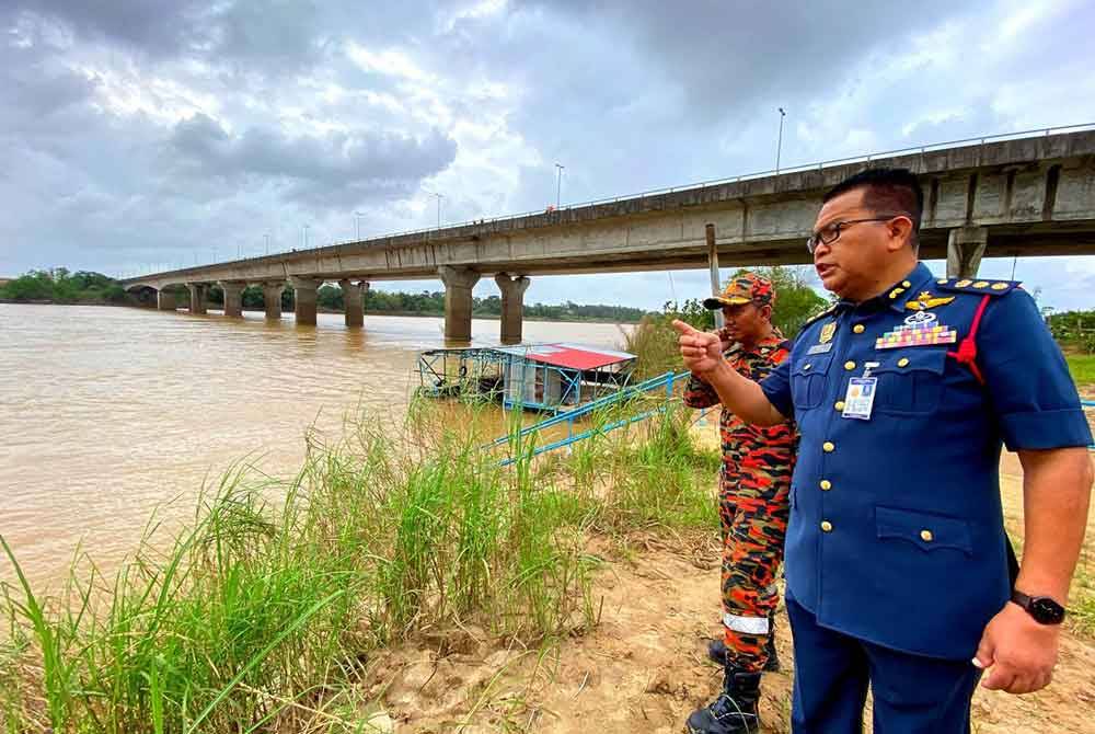 Zainal (kanan) semasa turun padang ke lokasi kejadian seorang lelaki dikhuatiri lemas selepas terjatuh dari Jambatan Sultan Ismail Petra ke dalam Sungai Kelantan di Tendong di Pasir Mas.