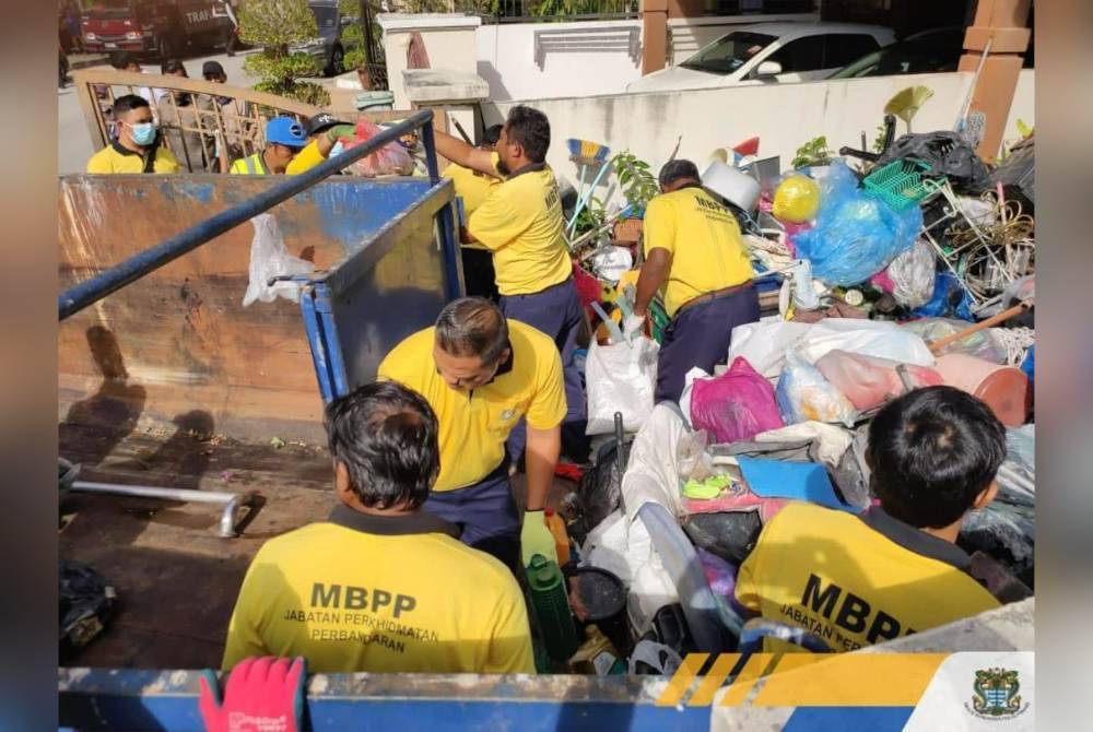 Pekerja MBPP giat membersihkan kawasan rumah tersebut selepas notis yang diserahkan tidak dipedulikan oleh pemilik premis. Foto Facebook MBPP