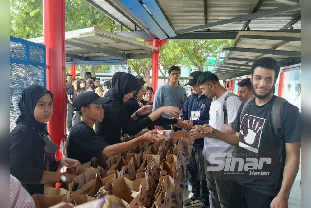 Pelajar beratur untuk mendapatkan pek makanan percuma dalam Program Taco Bell Give Away di Central Plaza, Universiti Multimedia pada Selasa.