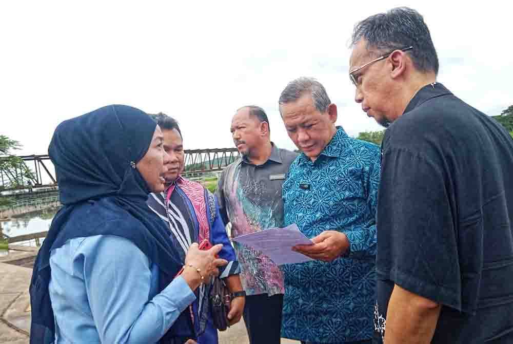 Aminuddin (dua kanan) ketika mendengar penjelasan mengenai pencemaran yang dikesan ketika meninjau Loji Rawatan Air Sungai Linggi pada Khamis.