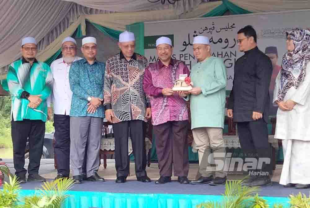 Nassuruddin (empat dari kanan) menyerahkan replika banglo kepada Muhammad Qayyim sebagai tanda penyerahan rumah banglo kepada johan Tilawah Al-Quran Peringkat Antarabangsa 2023 itu pada Khamis.