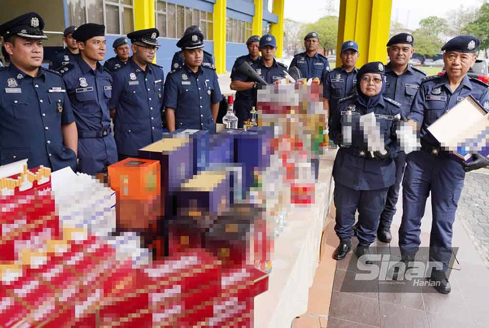 Norlela bersama pegawai Jabatan Kastam Diraja Malaysia(JKDM) menunjukkan antara rokok serta minuman keras yang dirampas.Foto Sinar Harian-ROSLI TALIB