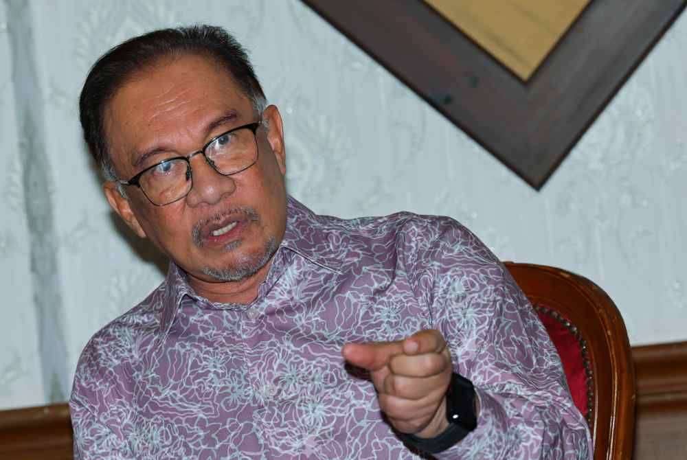 Anwar bercakap pada sidang media sempena pemukiman bersama Jemaah Menteri di sebuah hotel hari ini. Foto Bernama