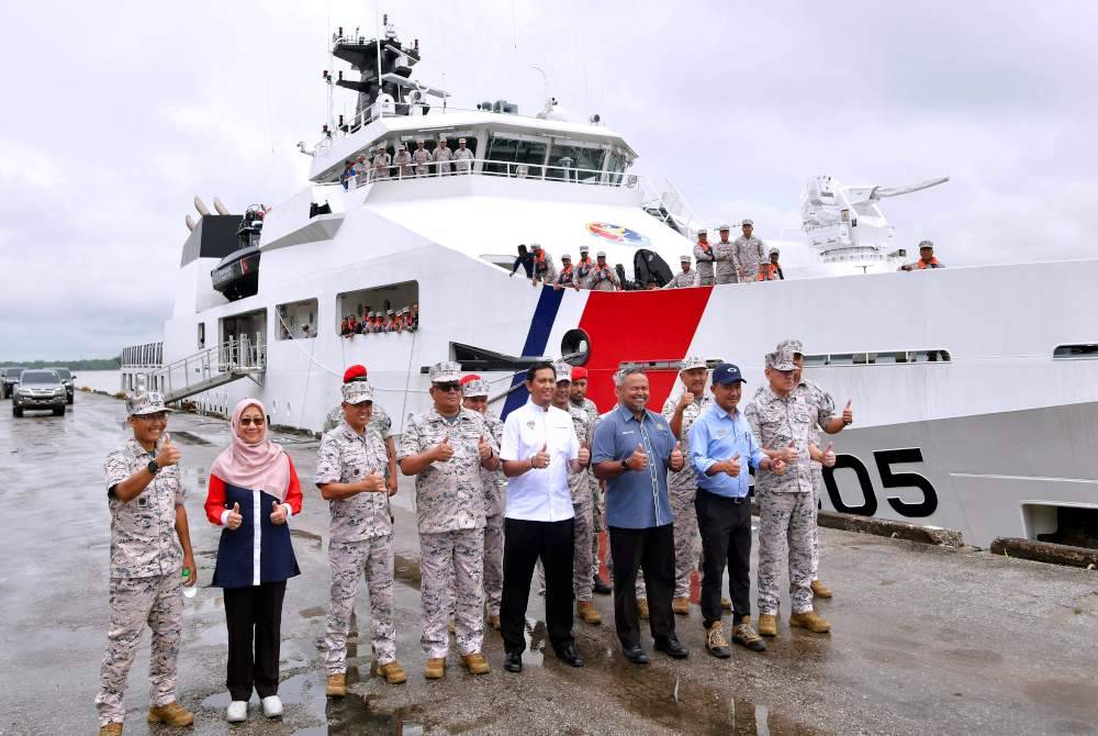 Ruji (depan dua, kanan) bergambar kenangan bersama Hamid dan anggota kru Kapal Peronda Luar Pesisir pertama (OPV1) APMM selepas membuat tinjauan di sekitar perairan Sarawak hari ini. Foto Bernama