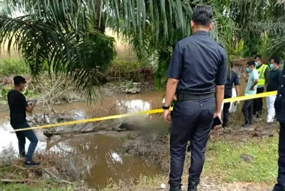 Polis memeriksa lokasi mayat yang ditemui di dalam parit di Jalan Tali Air 11 Pasir Panjang Sekinchan, di sini pada Khamis.