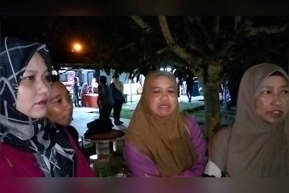 Norhisham (kiri) dan ibu Bella, Noraini beradi di lokasi penemuan mayat di Kampung Batu 7, Tongkang Pecah.