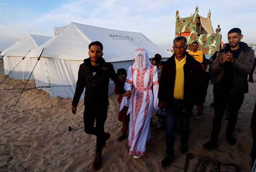 Mohammed Al-Ghandour dan pasangannya, Shahad melangsungkan perkahwinan di khemah penempatan pelarian di Rafah. - Foto Reuters