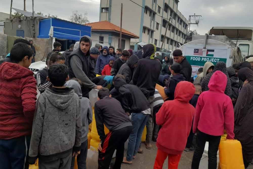 Penduduk di utara Gaza, Palestin beratur untuk menunggu giliran mengambil air bersih sumbangan rakyat Malaysia yang diuruskan pihak Ihsan Johor.