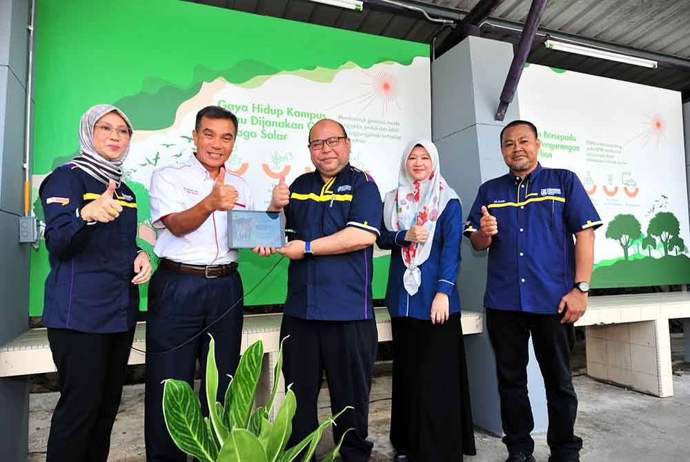 Dari kiri; Arnis, Mohamad Zuki dan Md Yusof ketika melakukan simbolik pengecasan gajet di salah sebuah perhentian bas berkuasa solar di UiTM Shah Alam.