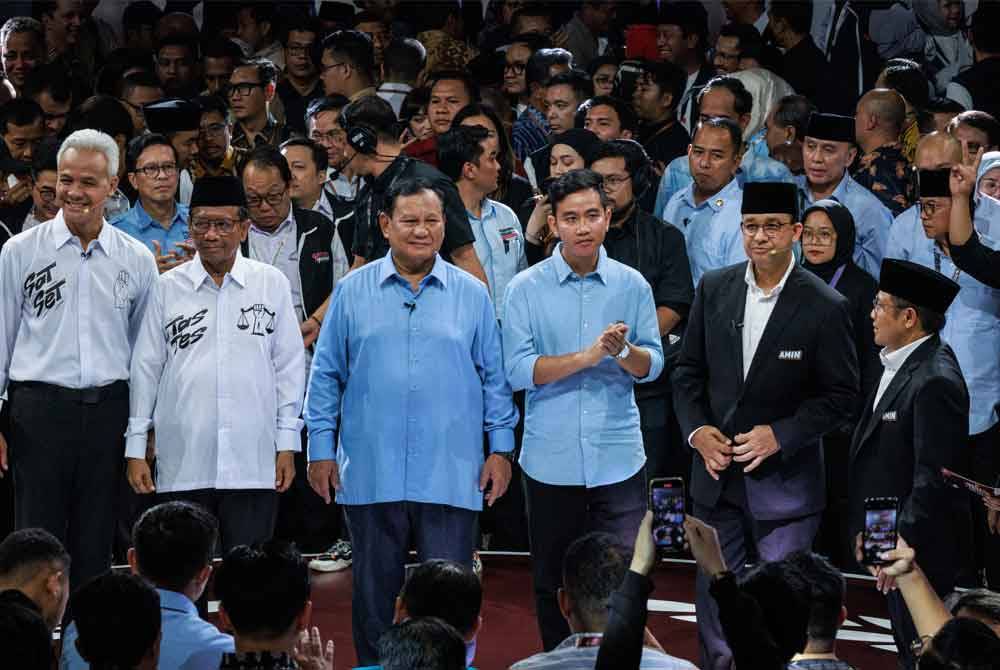 Calon dan naib presiden bergambar semasa debat pertama di Jakarta. - AFP