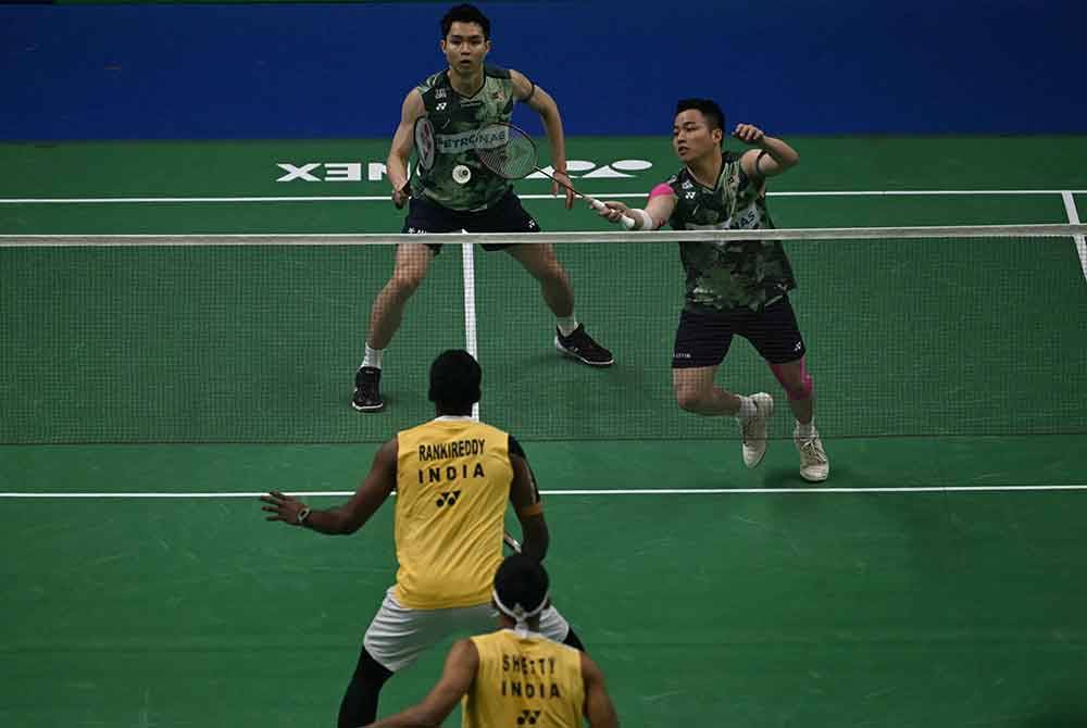 Aaron (kanan) dan Wooi Yik (kiri) ketika menentang wakil tuan rumah, Satwiksairaj Rankireddy-Chirag Shetty semasa perlawanan separuh akhir beregu lelaki Kejohanan Badminton Super 750 Terbuka India di Stadium Indira Gandhi. Foto AFP