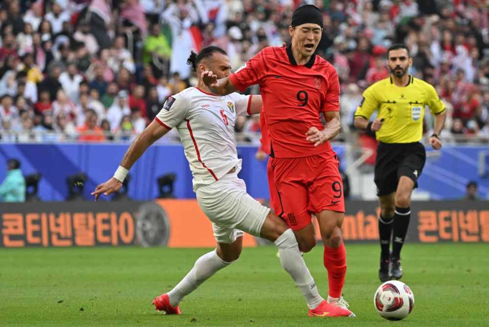 Penyerang Korea Selatan, Cho Gue-sung dihalang oleh pertahanan Jordan, Yazan al-Arab dalam aksi Piala Asia pada Sabtu. Foto AFP