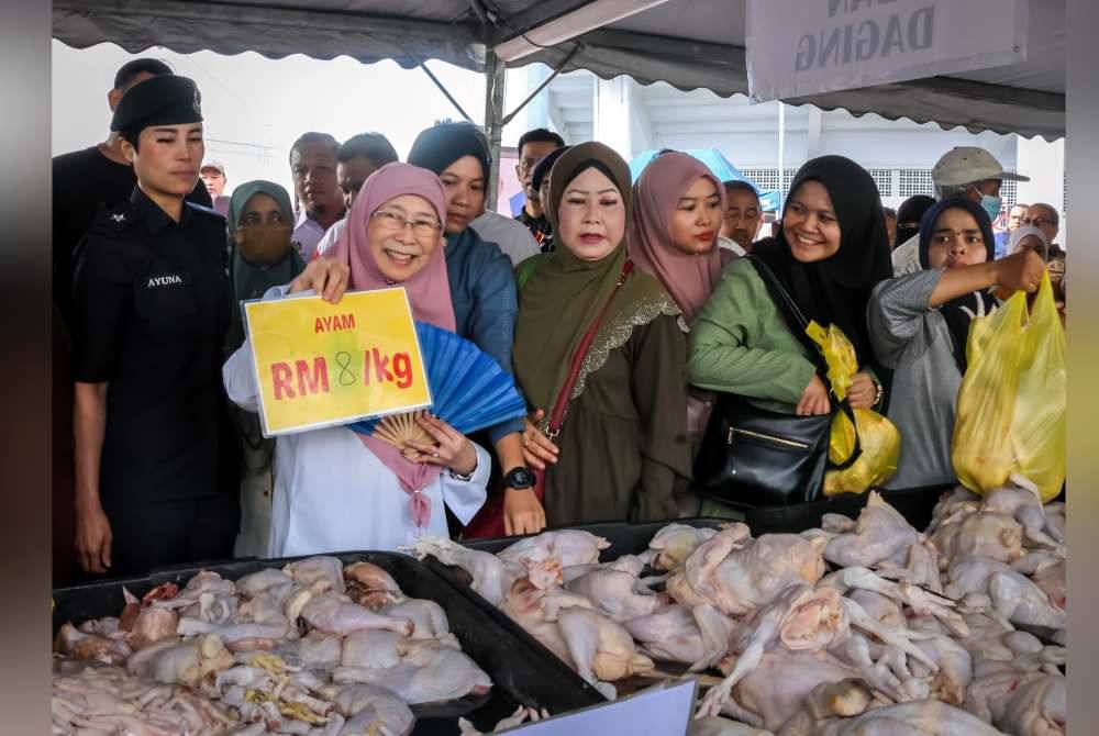 Wan Azizah menunjukkan harga jualan ayam sekilogram ketika hadir pada program Jualan Termurah Khidmat Demi Rakyat di Stadium Bola Kuala Lumpur pada Ahad. Foto Bernama