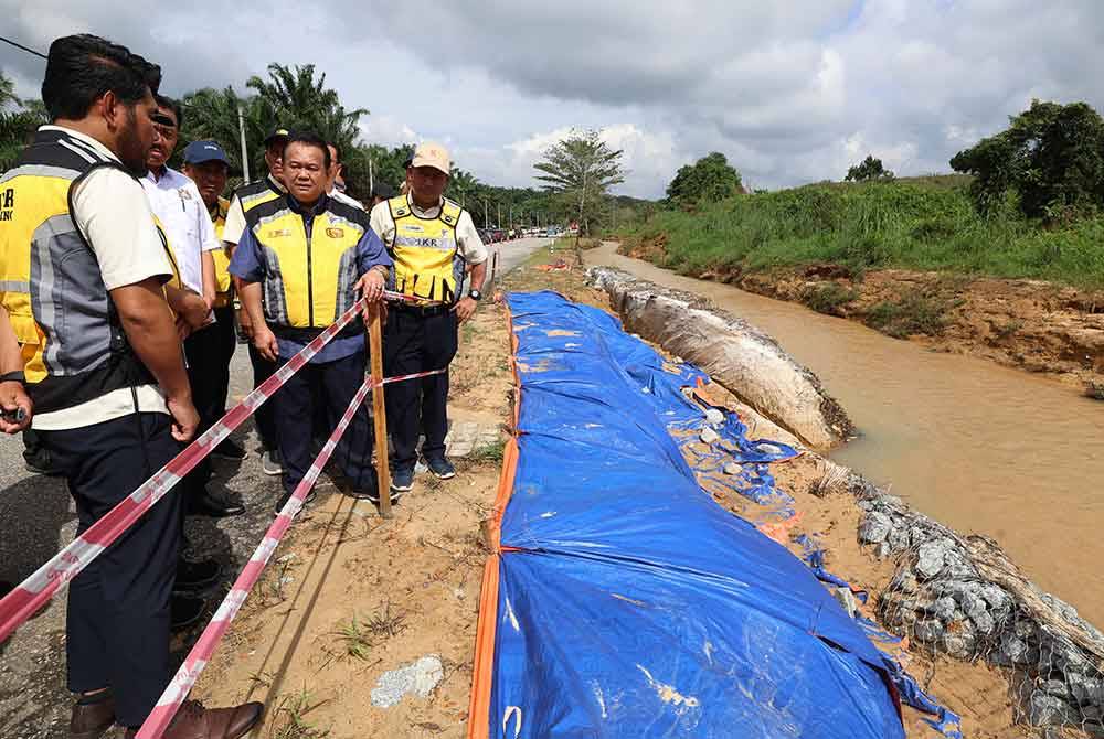 Alexander (dua, kanan) meninjau saliran sungai di laluan FT003 Johor Bahru-Mersing yang terjejas banjir tempoh hari. Foto Bernama