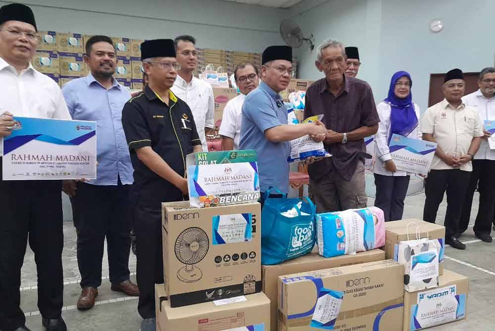 Mohd Na&#039;im menyampaikan bantuan kepada penerima dalam program Misi Bantuan Pasca Banjir Agensi di Bawah Menteri di Jabatan Perdana Menteri (Hal Ehwal Agama) di Dewan Kampung Sungai Telor, Kota Tinggi pada Ahad