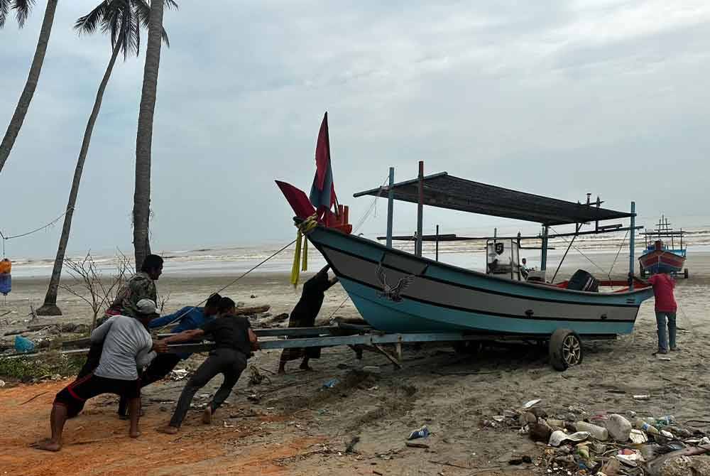 Nelayan saling membantu menolak bot untuk turun ke laut.