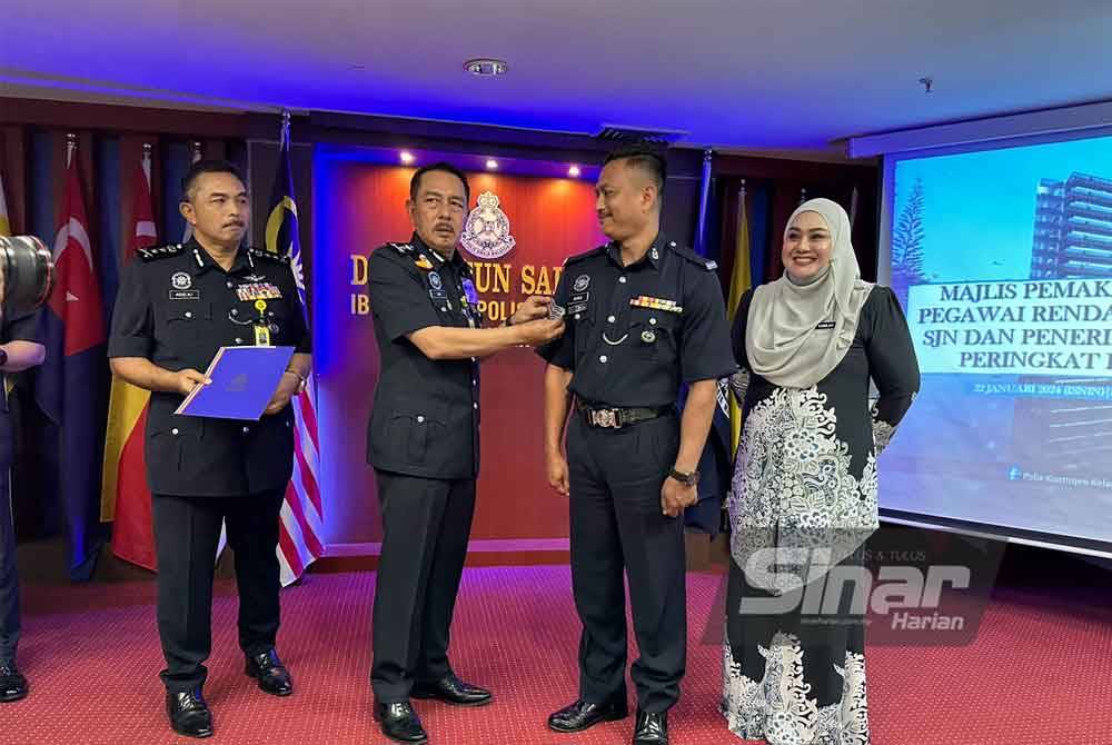 Muhamad Zaki (dua dari kiri) memakaikan pangkat kepada Sarjan Rasidi Mohamed Ali Hanapiah (dua dari kanan) yang bertugas di Jabatan Siasatan Jenayah IPK Kelantan.