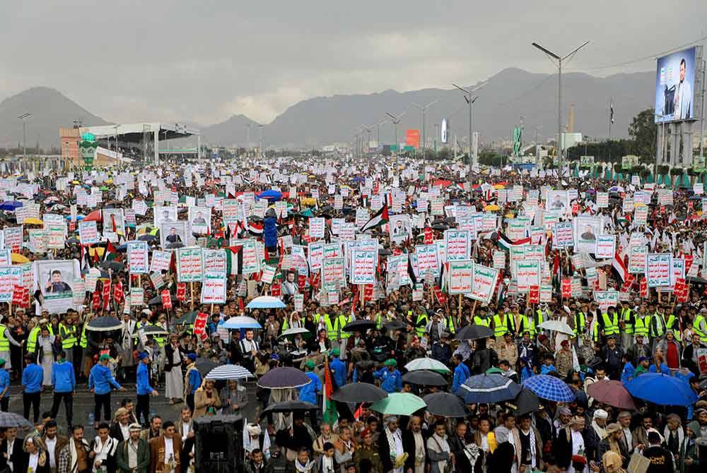 Orang ramai mengangkat sepanduk, bendera Palestin dan Yaman ketika perhimpunan anti-Israel dan anti-AS di Sanaa, Yemen pada Jumaat. Foto AFP