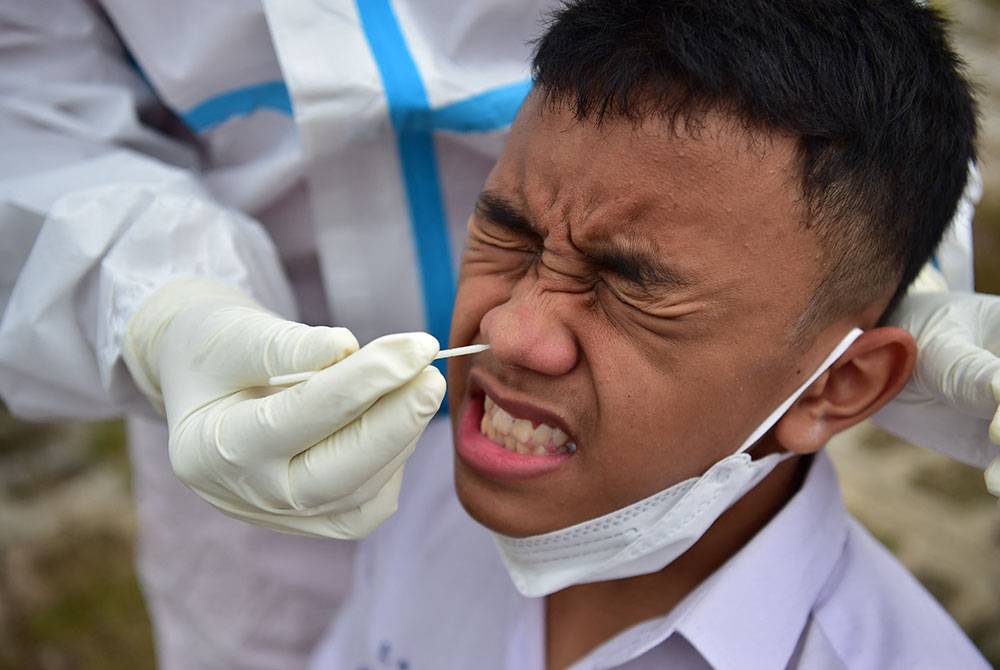 Pegawai kesihatan melakukan ujian Covid-19 terhadap pelajar dan guru di Narathiwat, selatan wilayah Thailand. - AFP