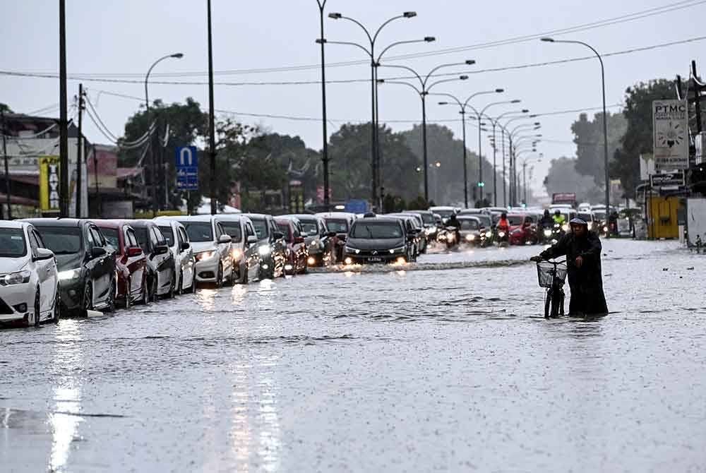 Pemandu kenderaan mengharungi air yang melimpahi jalan selepas hujan lebat sejak malam tadi ketika tinjauan fotoBernama di Simpang Tok Ku pada Selasa. Foto Bernama