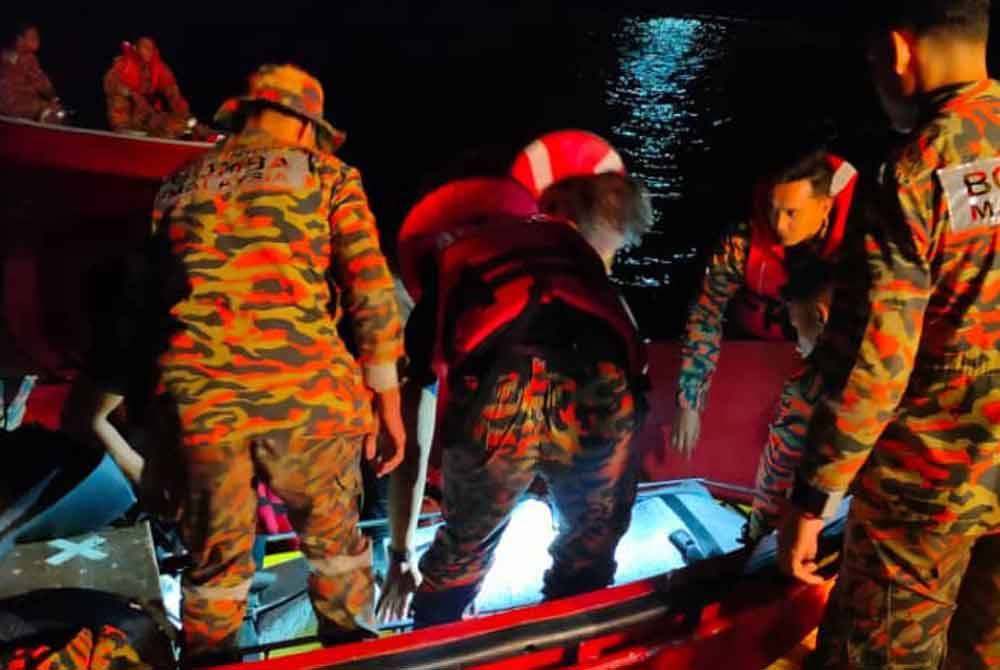 Pasukan bomba dan penyelamat menyerahkan mangsa kepada pihak polis untuk tindakan selanjutnya dalam kejadian lemas di Tasik Temenggor, Gerik pada Selasa.