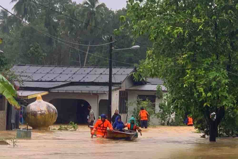 Anggota APM Pasir Puteh sedang melakukan kerja-kerja menyelamatkan penduduk di Kampung Batu Hitam, Pasir Puteh. Foto APM Pasir Puteh