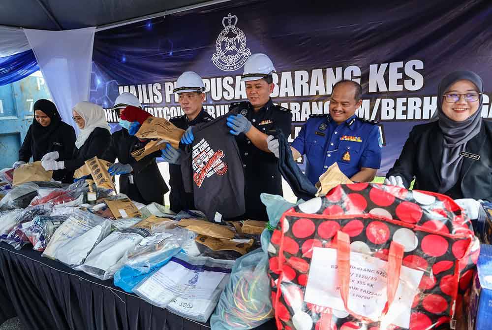 Mohd Khairi (tiga dari kanan) menunjukkan sampul berisi barang kes yang dilupuskan pihaknya pada majlis di Balai Polis Kapar, Klang pada Rabu.