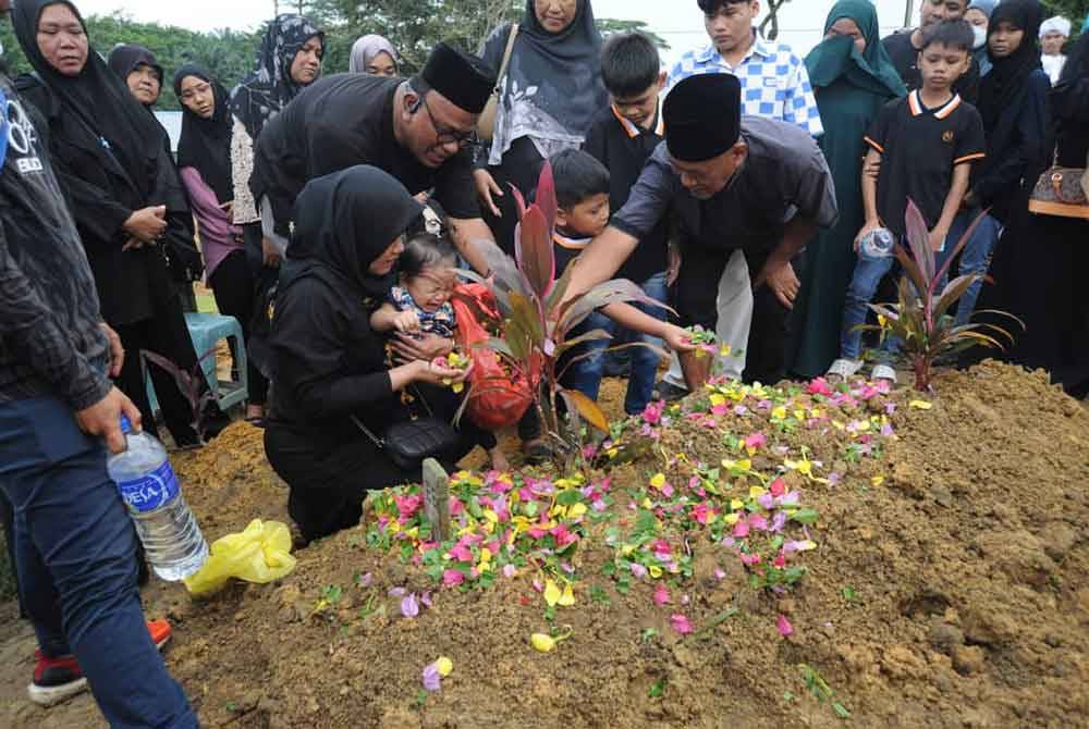 Keluarga menenangkan anak Allahyarham Bella, Maream Isabel yang menangis ketika berada di pusara ibunya.