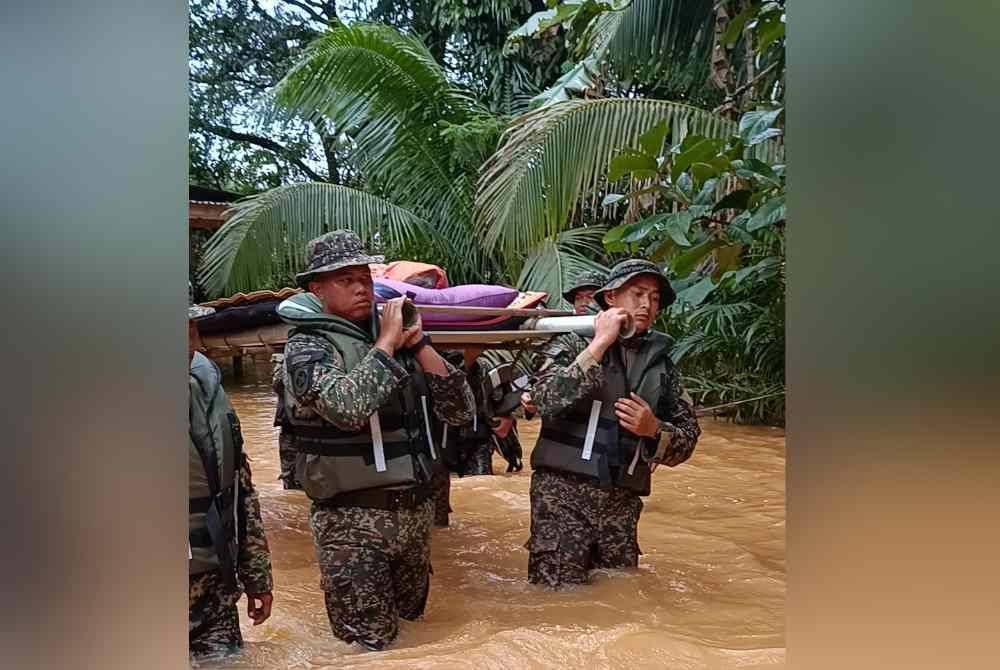 
Pasukan ATM mengharung banjir sedalam lebih satu meter bagi membawa jenazah Kalthom yang meninggal dunia di rumahnya akibat sakit tua.