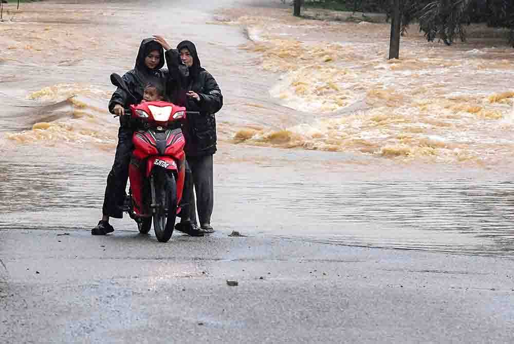 Penduduk terpaksa berpatah balik berikutan jalan menghubungkan Kampung Keroh ke Ladang Pasir Gajah ditenggelami banjir ekoran hujan lebat sejak dua hari lalu ketika tinjauan di Kuala Krai - Foto Bernama.