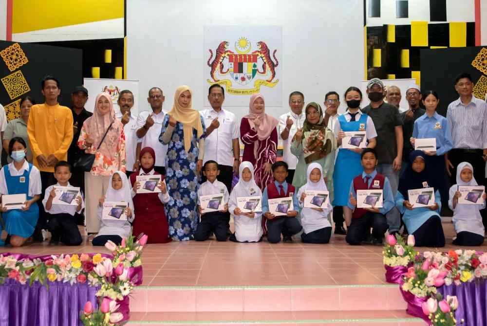 Fadhlina (tengah) bergambar bersama sebahagian para penerima Peranti Wakalah Zakat di SMK Labuan sempena lawatan rasmi beliau ke Labuan hari ini. Foto Bernama