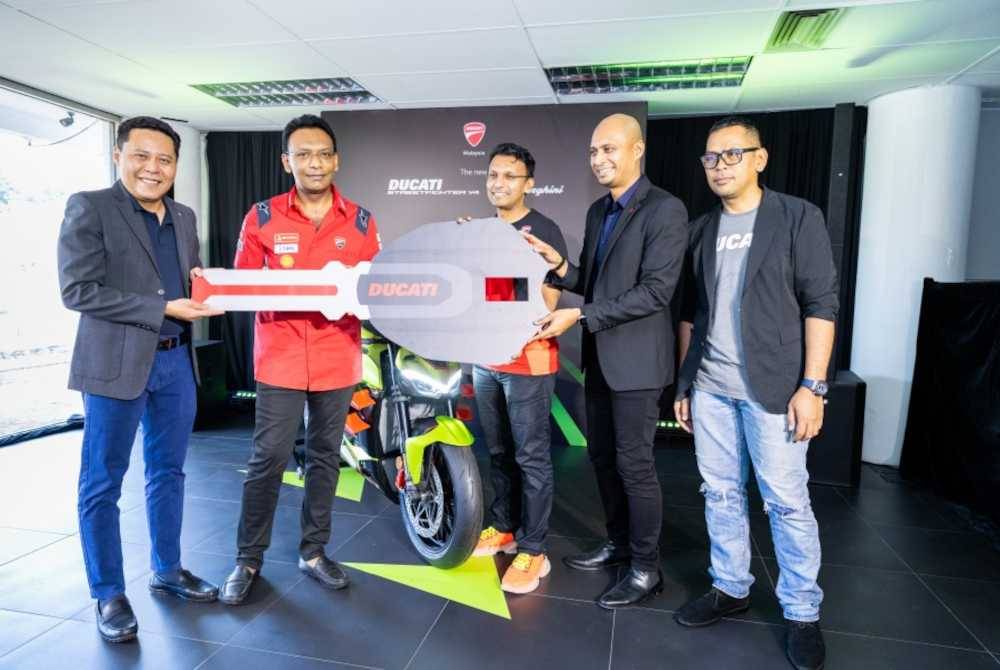 Michael (dua dari kiri) menyerahkan replika kunci kepada Nazir Hussin yang menjadi pemilik pertama Ducati Streetfighter V4 Lamborghini di negara ini.