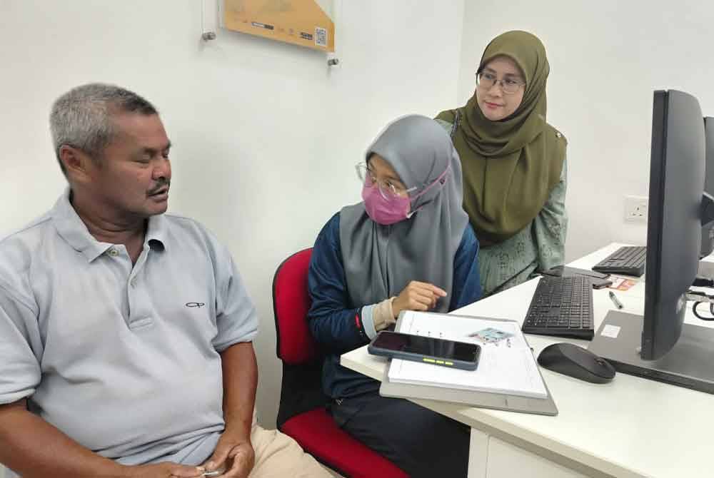 Kakitangan PEDi memberi penerangan kepada Zainol (kiri) sambil disaksikan Nadia (kanan) di PEDi Kampung Perik, Kuala Nerang.