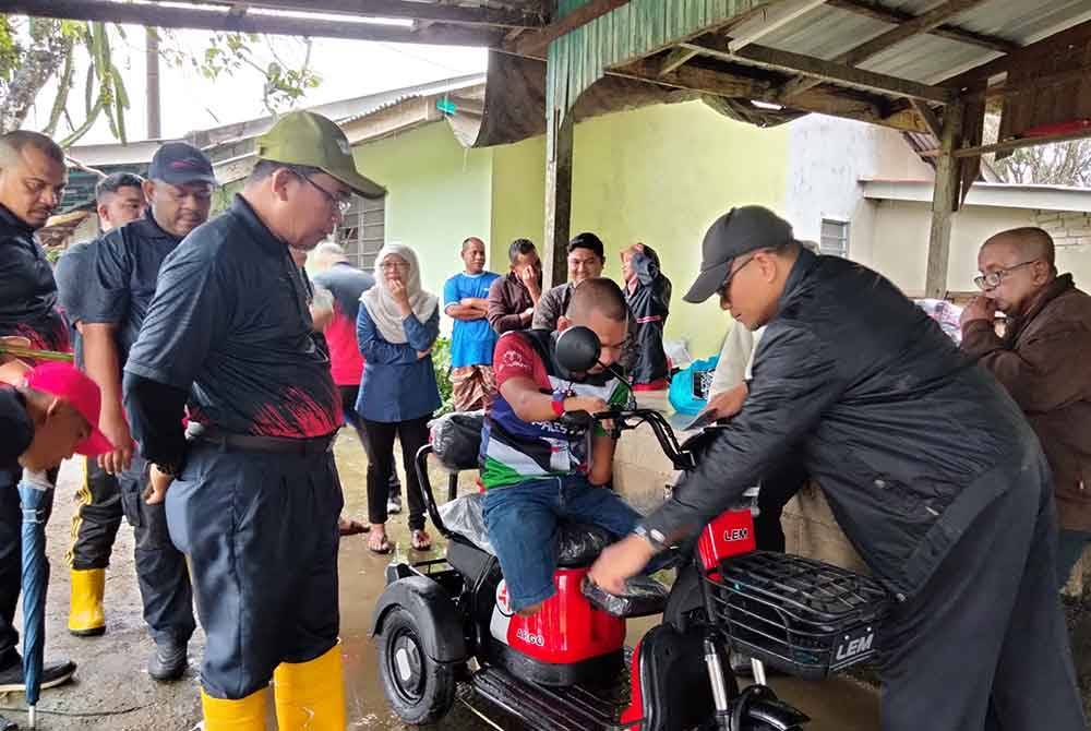 Ibrahim mencuba motosikal elektrik yamg disumbangkan oleh Yayasan Raja Shamri.