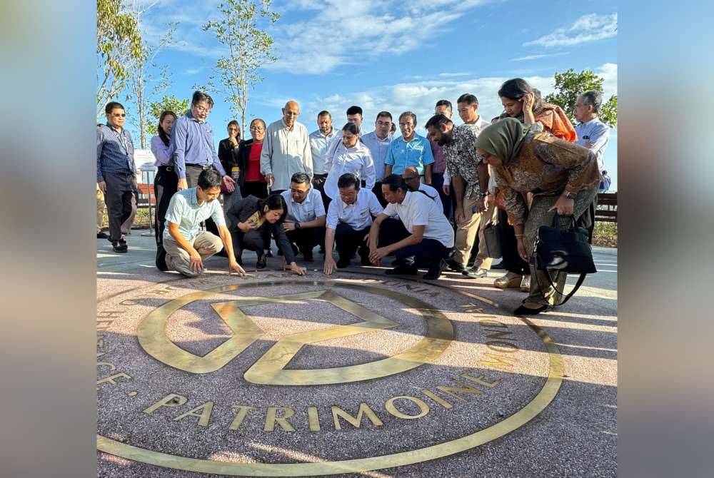 Kon Yeow (duduk, dua dari kanan) merasmikan Projek Linear Garden di Padang Kota pada Isnin.