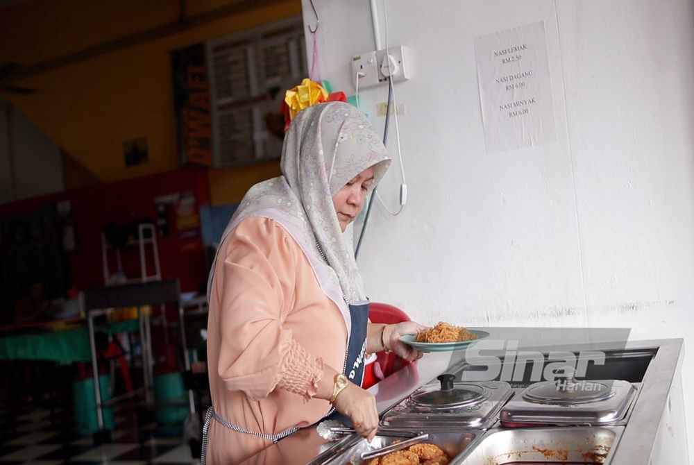 Rosnida menyediakan juadah kepada pelanggan di restorannya di Kuantan, baru-baru ini.