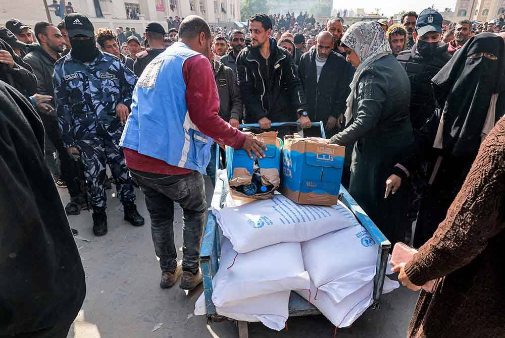 Kakitangan UNRWA mengedarkan tepung dan bantuan makanan kepada penduduk di Genting Gaza. - AFP