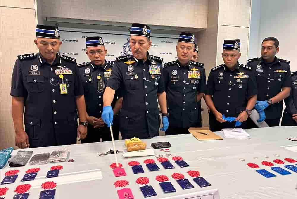 Muhamad Zaki (tiga dari kiri) menunjukkan dadah jenis pil kuda yang dirampas dalam tangkapan di Pasir Mas.