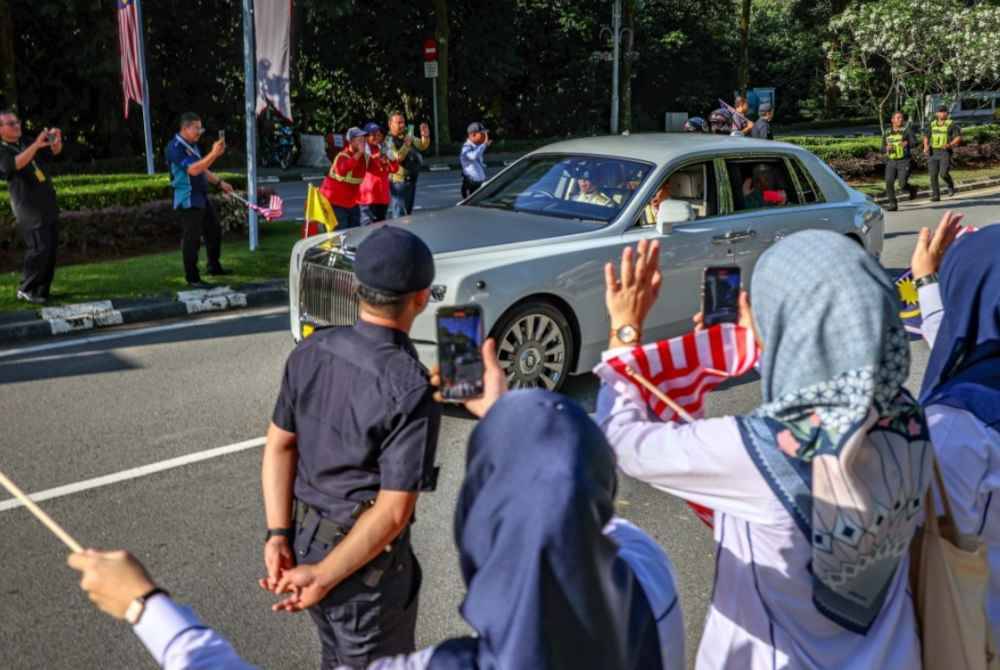 Orang ramai berbaris di sepanjang laluan di Jalan Parlimen bagi mengiringi keberangkatan balik Al-Sultan Abdullah dan Tunku Azizah. Foto Bernama