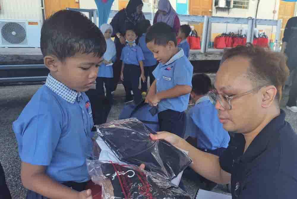 Pengurus Perhubungan Media, Jabatan Komunikasi Korporat Bernas, Dzul Affandi Mat Noor beramah-mesra bersama kanak-kanak yang menerima sumbangan kelengkapan persekolahan.