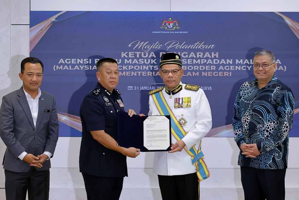 Menteri Dalam Negeri Datuk Seri Saifuddin Nasution Ismail (dua, kanan) menyampaikan surat pelantikan sebagai Ketua Pengarah Agensi Pintu Masuk dan Sempadan Malaysia kepada Datuk Seri Hazani Ghazali (dua dari kiri) di KDN pada Rabu. Foto Bernama