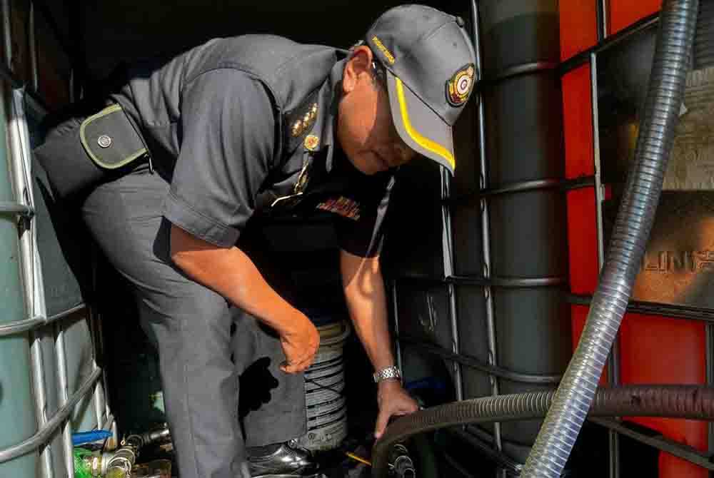 Pegawai KPDN memeriksa bahagian muatan lori dan menemukan cecair disyaki diesel bersubsidi di sebuah stesen minyak di Ayer Tawar, Manjung. Foto ihsan KPDN Perak